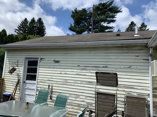 A white house with a table and chairs in front of it.