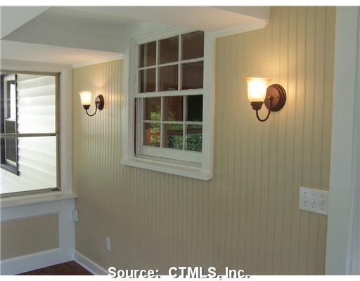 A room with a window and two lights on the wall