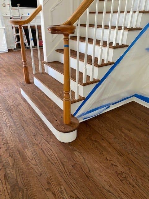 A staircase with a wooden railing and a white railing