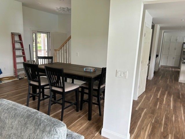 A living room with a table and chairs and a ladder.