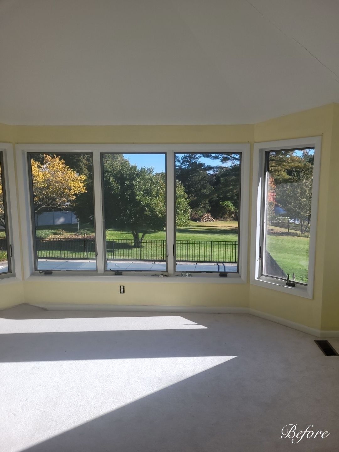 An empty room with a view of a golf course