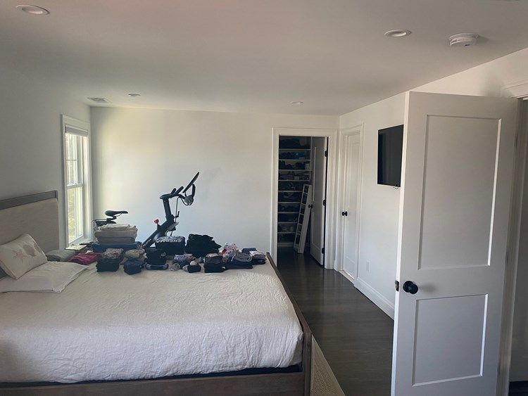 A bedroom with a large bed and a bicycle on the floor.