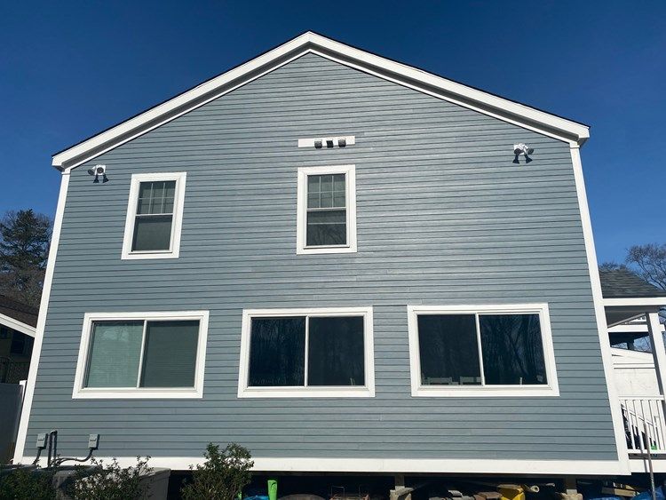A large house with a lot of windows and a blue sky in the background