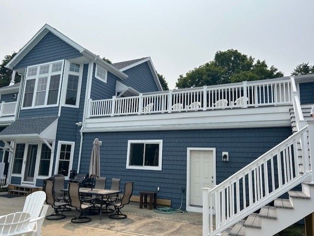 A blue house with a white deck and stairs