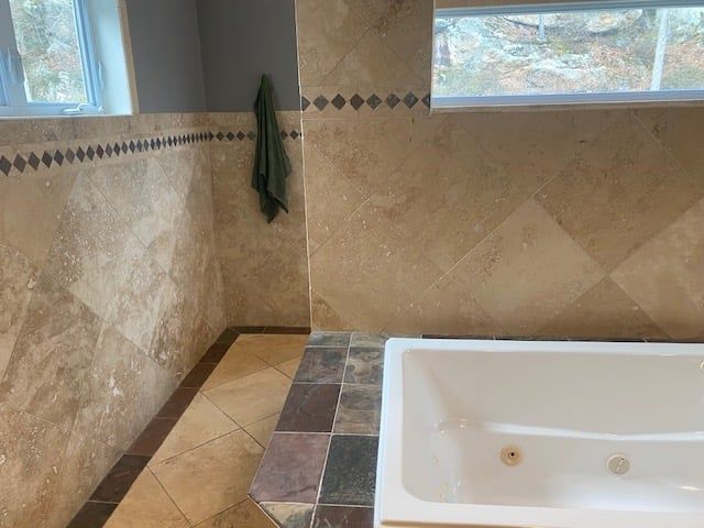 A bathroom with a bathtub and a window.