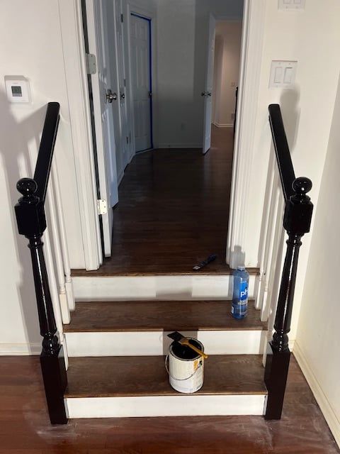 A bucket of paint sits on the steps of a staircase