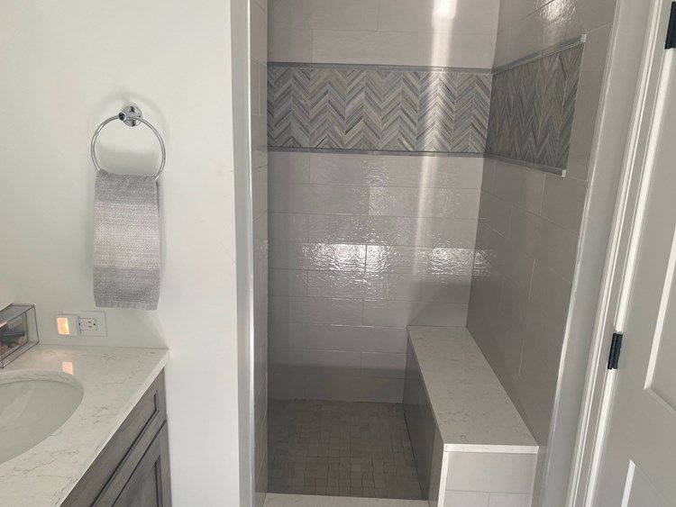 A bathroom with a sink and a walk in shower.
