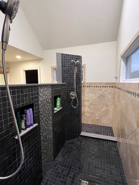 A bathroom with a walk in shower and a window