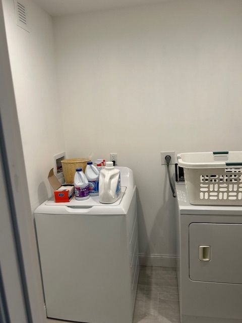 A laundry room with a washer and dryer and a basket.