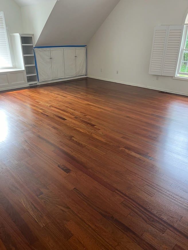 An empty room with hardwood floors and white walls.