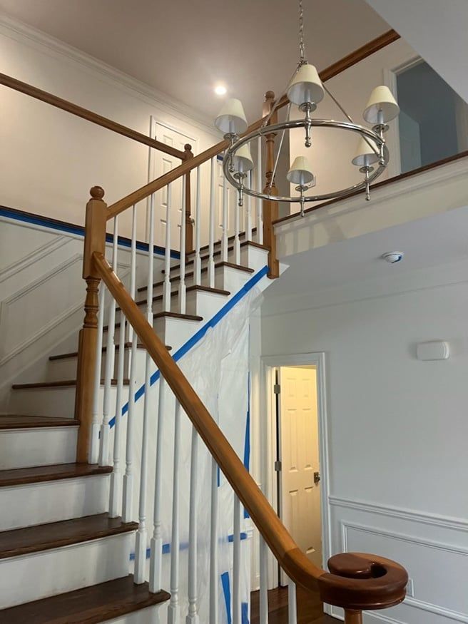 A staircase with a chandelier hanging from the ceiling