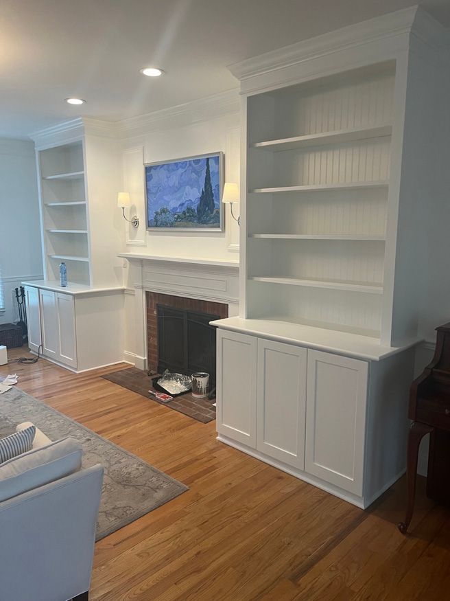 A living room with a fireplace , shelves , cabinets and a flat screen tv.