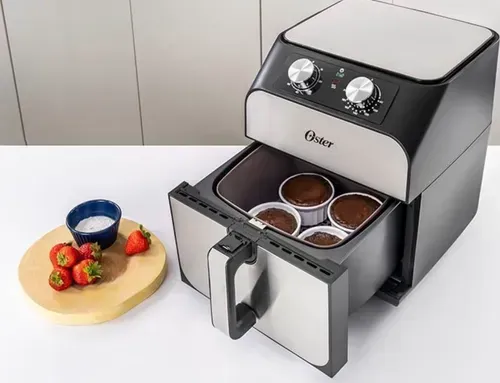 Freidora de aire con cupcakes, fresas y sal sobre una encimera.