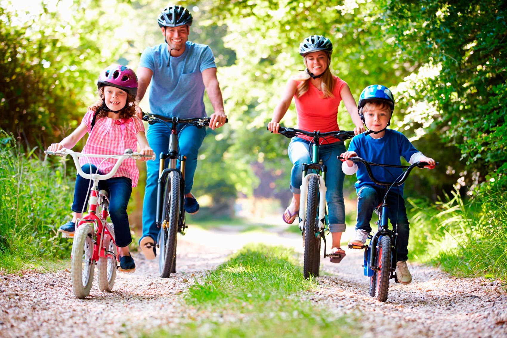 A family is riding bicycles down a dirt path.