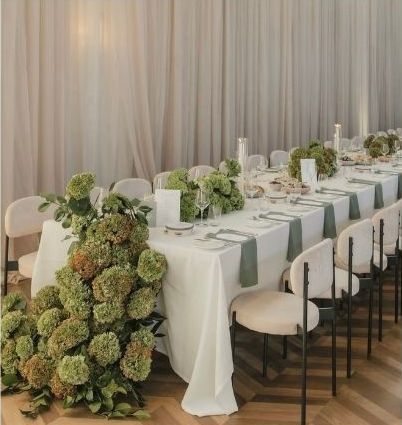 a long table with beautiful green florals