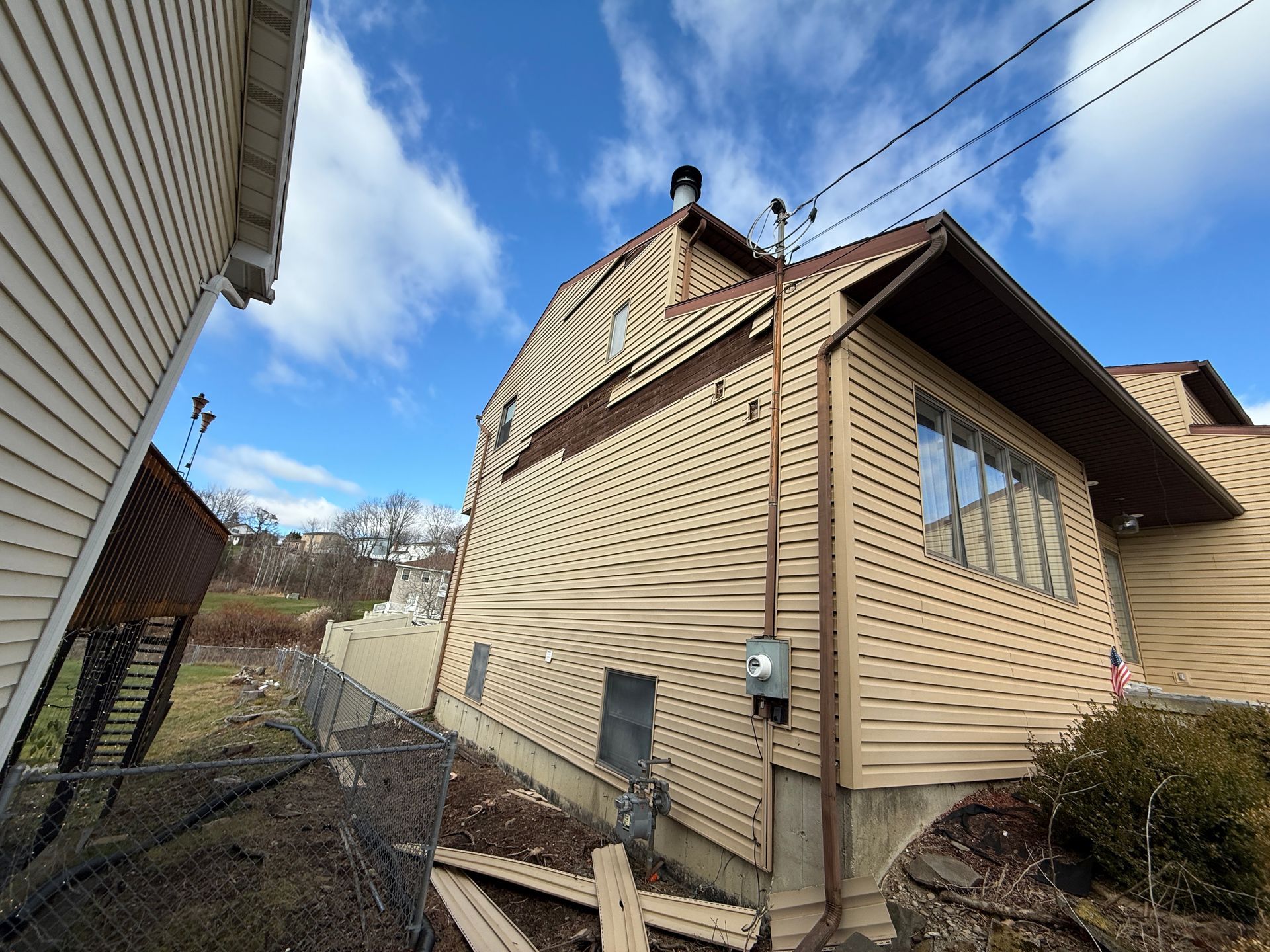 Beige house with brown trim and a blue sky.