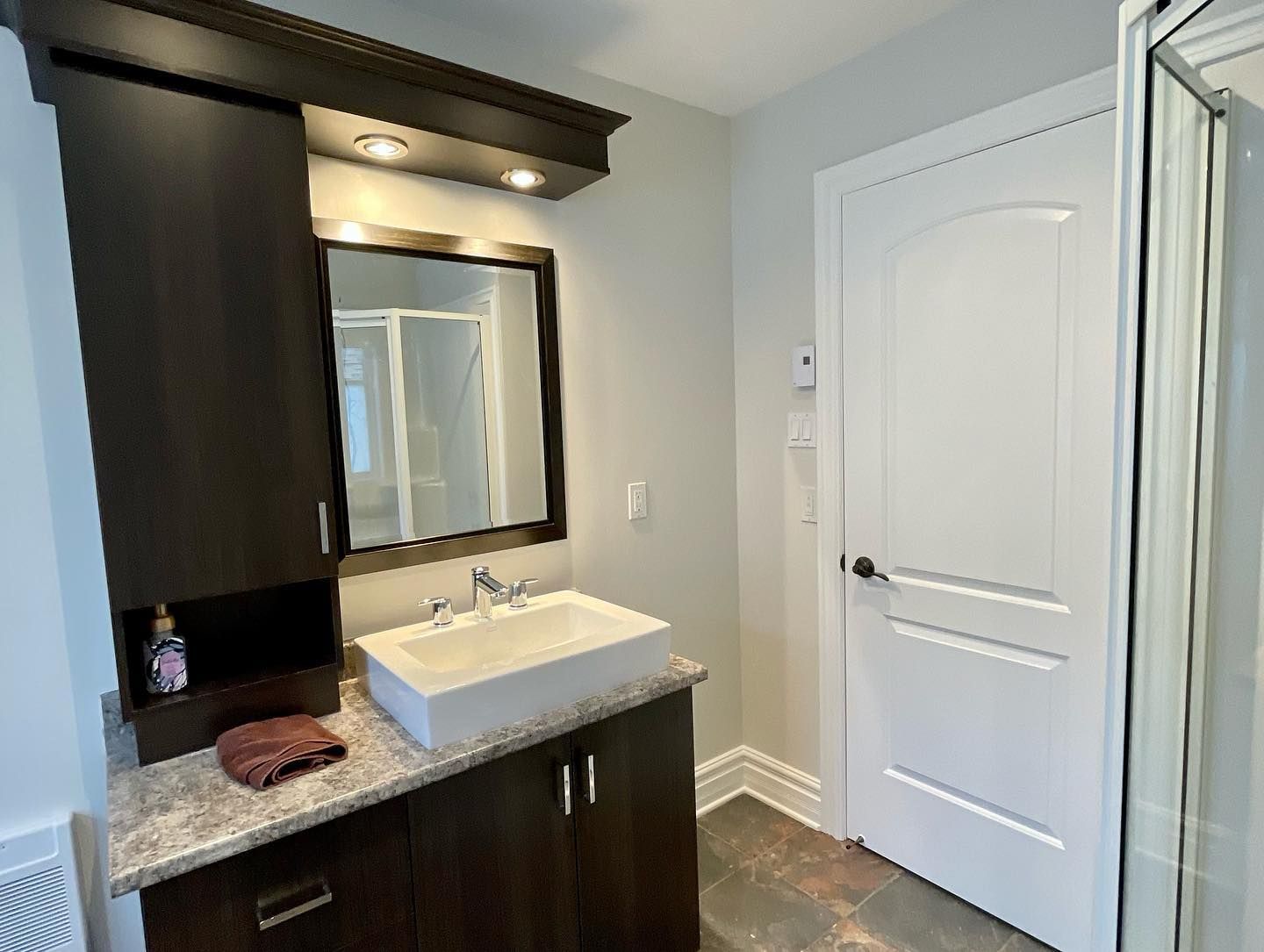 Une salle de bain avec un lavabo, un miroir et des armoires