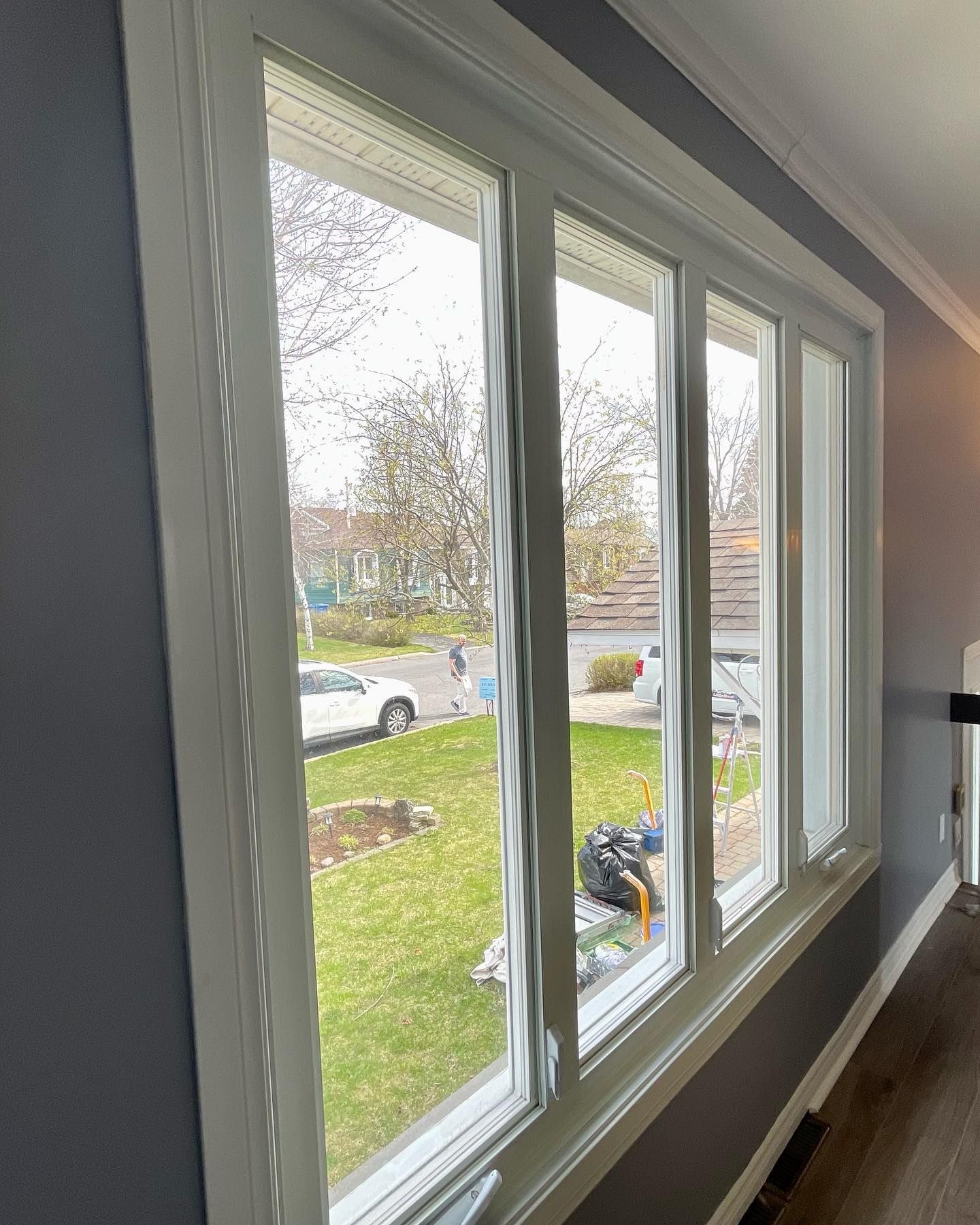 Un salon avec beaucoup de fenêtres et une vue sur une cour.