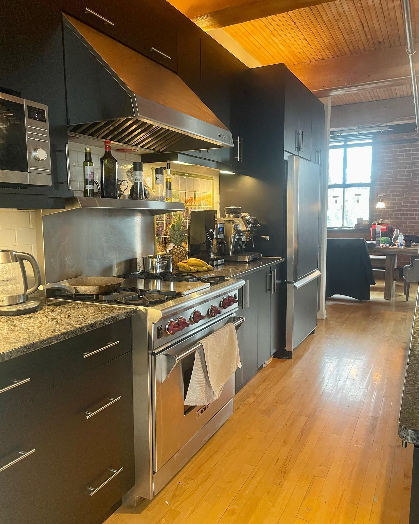 Une cuisine avec des appareils en acier inoxydable et des armoires noires