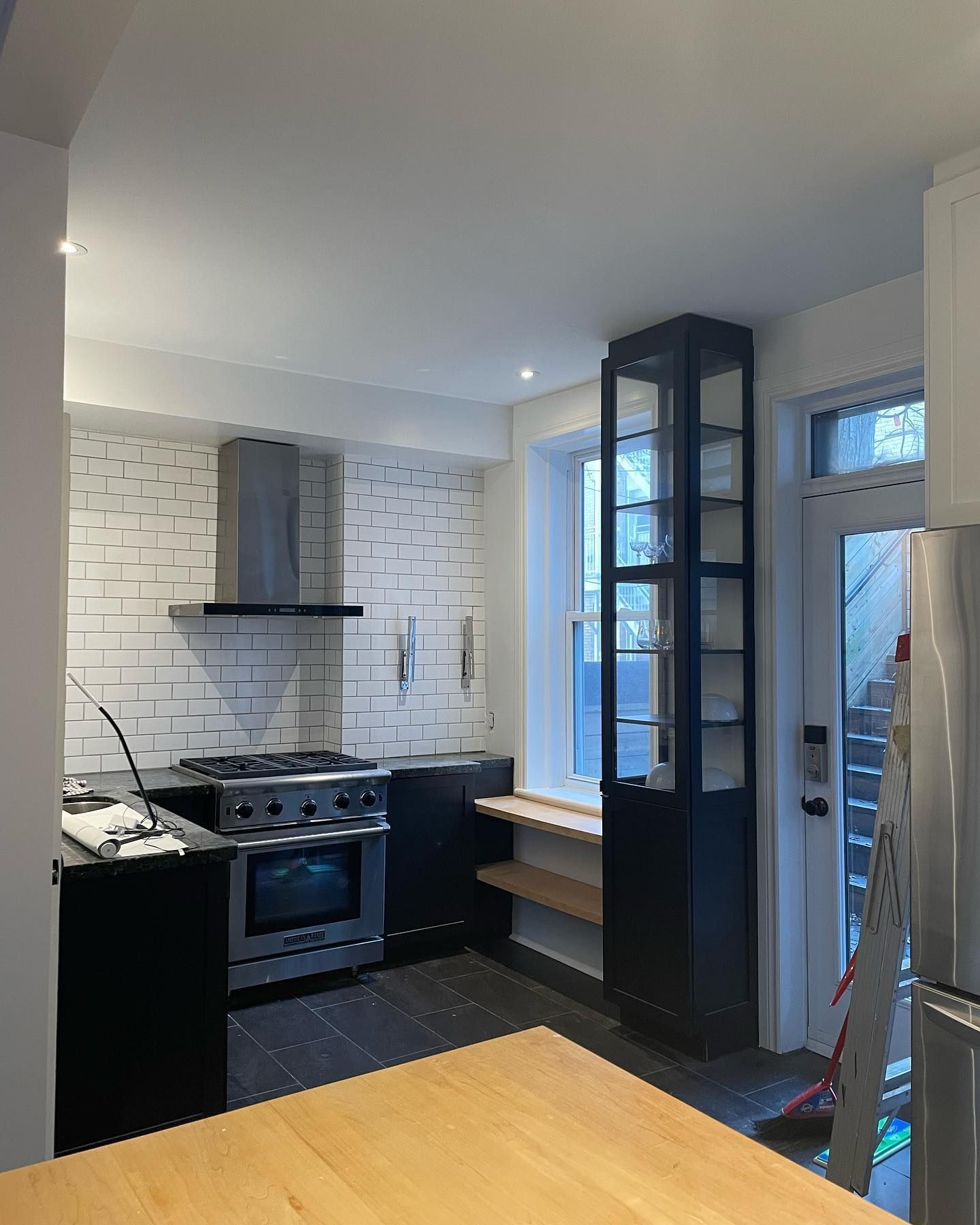 Une cuisine avec des appareils en acier inoxydable et une table en bois