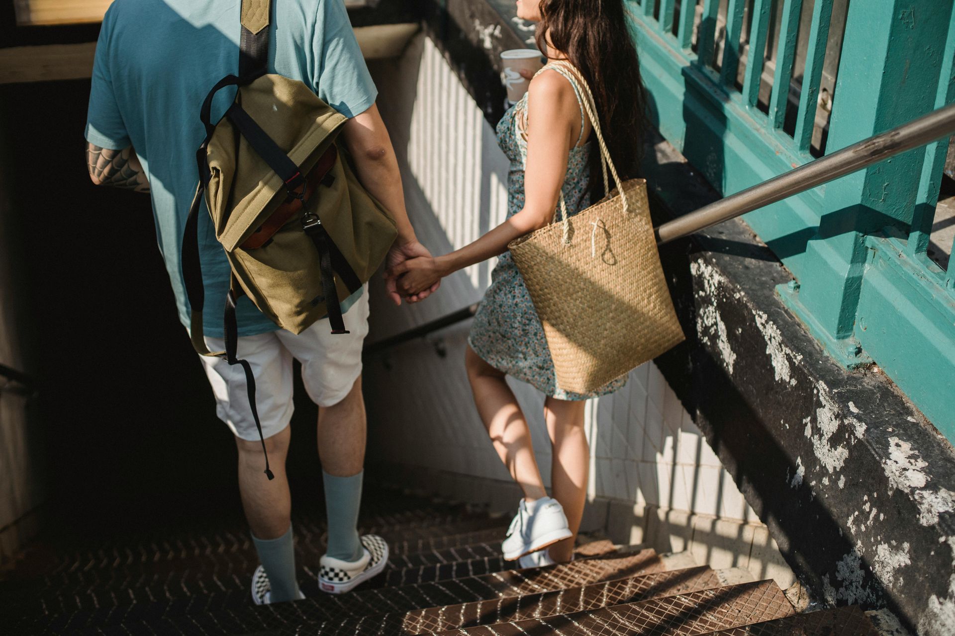A couple holding hands while walking up stairs, showing a symbol of togetherness.