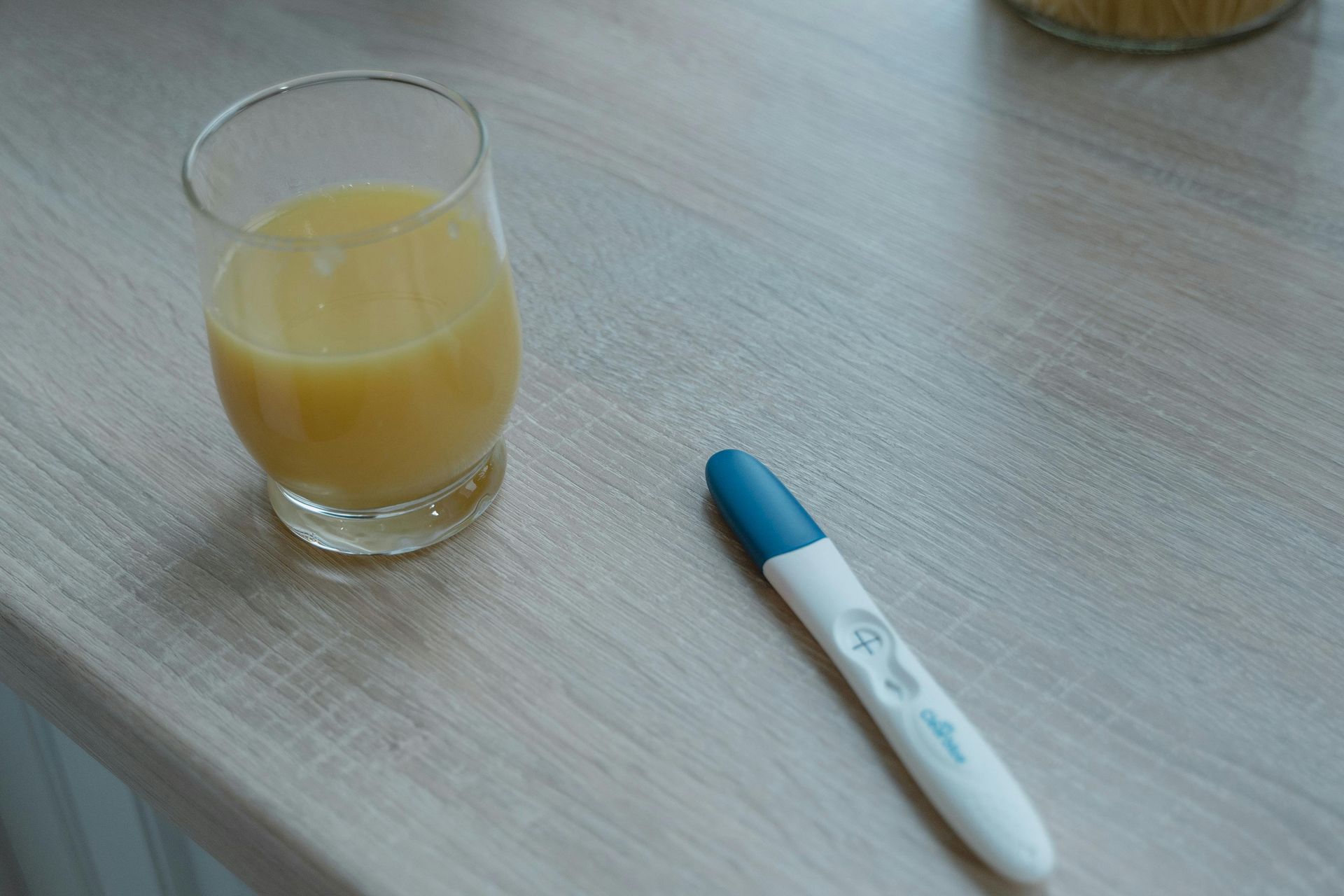 Pregnancy test on the table near a glass of orange juice