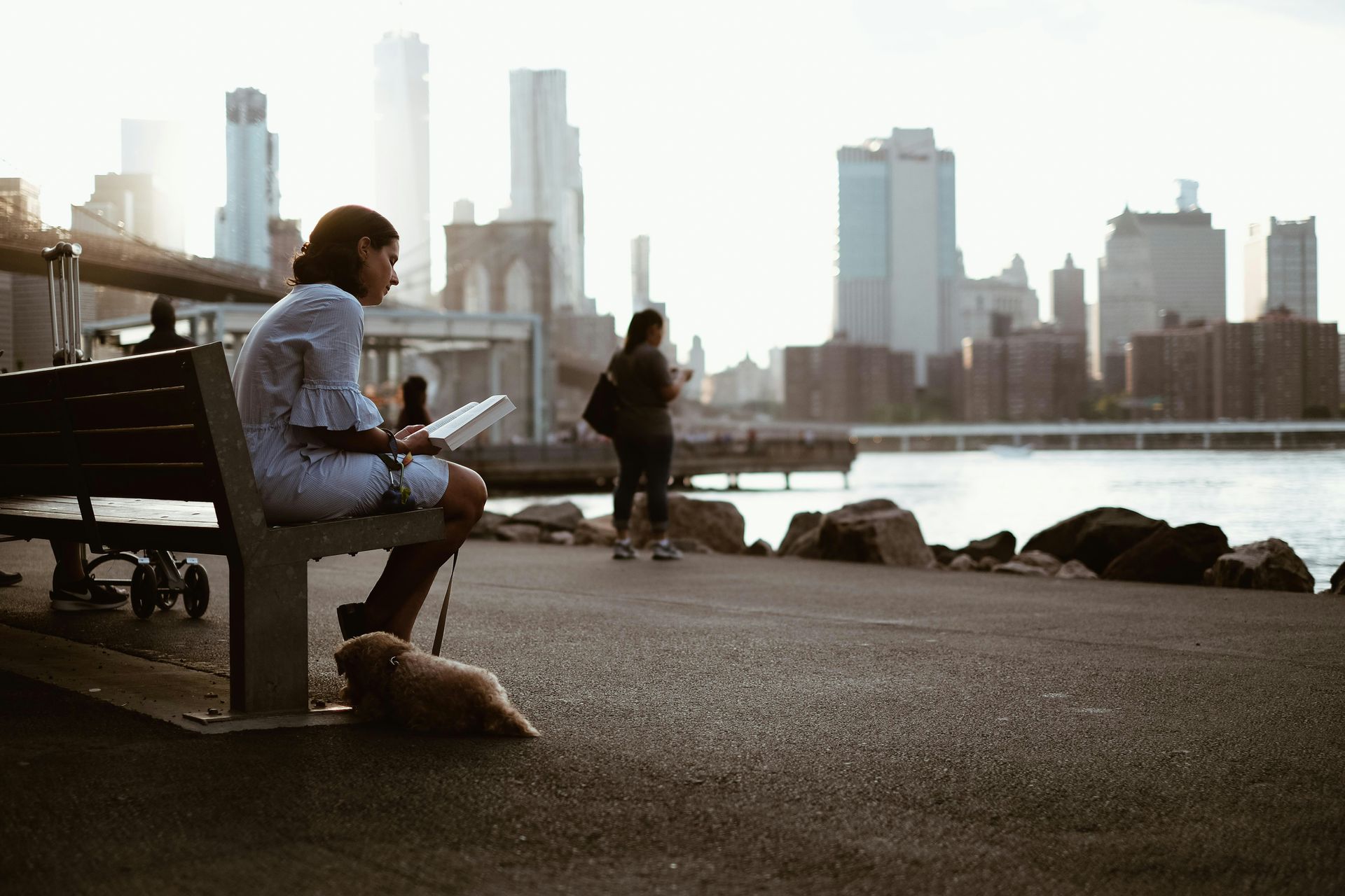 Woman sitting on bench reading a book in NYC