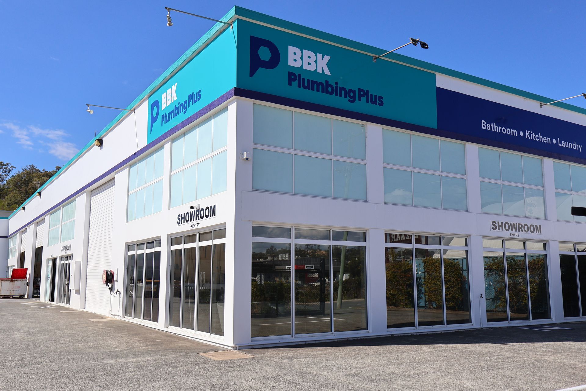 A large building with a lot of windows and a sign that says bbk plumbing plus