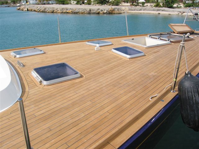 Bow's teak deck with window hatches, showcasing seamless integration of design and functionality in marine craftsmanship