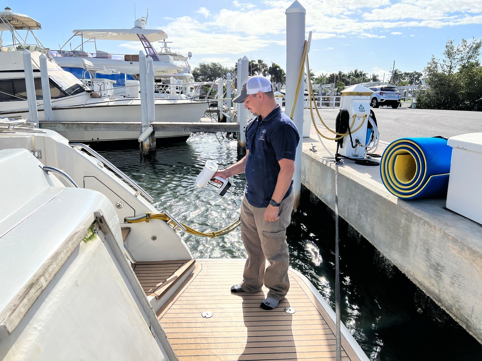 TDS worker expertly working on yacht exterior, showcasing  skill and dedication in craftsmanship at Teakdecking Systems