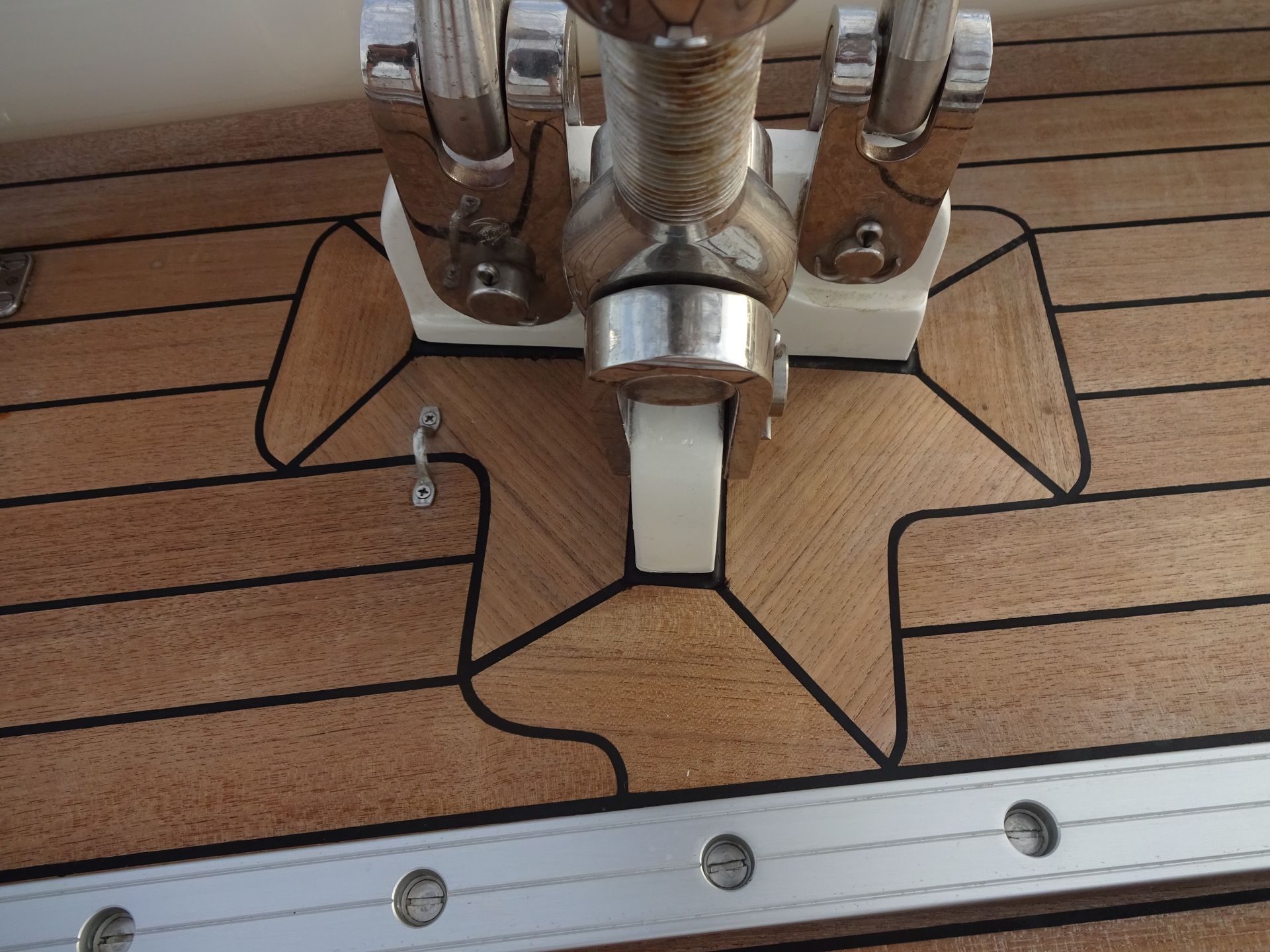 Decorative teak surrounding boat deck hardware, highlighting intricate craftsmanship and elegant marine design