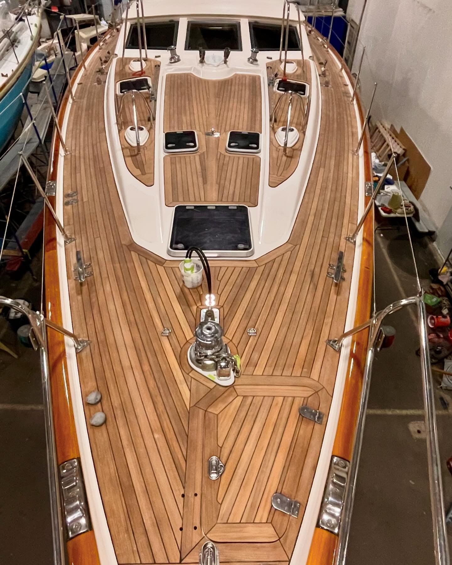 Bow's teak deck with window hatches, featuring an intricate design and pattern that blends functionality and craftsmanship