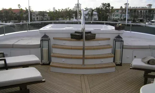 Teak decking on a yacht by Teakdecking Systems, featuring elegant stairs leading to a hot tub, showcasing luxury