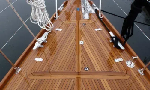 Stunning teak bow of a boat, showcasing the elegance and craftsmanship of the woodwork against the backdrop of the sea