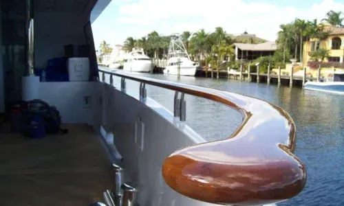 Close-up of Teakdecking Systems' custom high-gloss teak railing, uniquely designed for each yacht with precision