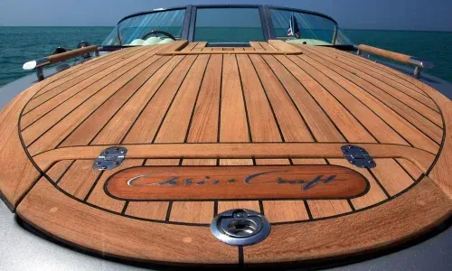 Teak deck bow of a Chris Craft boat, showcasing elegant woodwork and sleek design on the water.