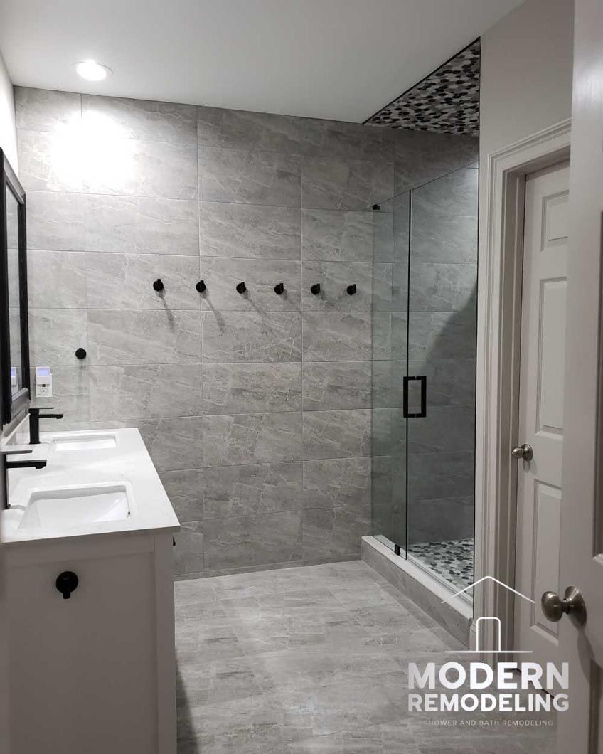 A bathroom with two sinks and a walk in shower.