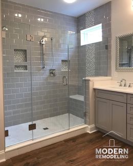 A bathroom with a walk in shower and a sink.