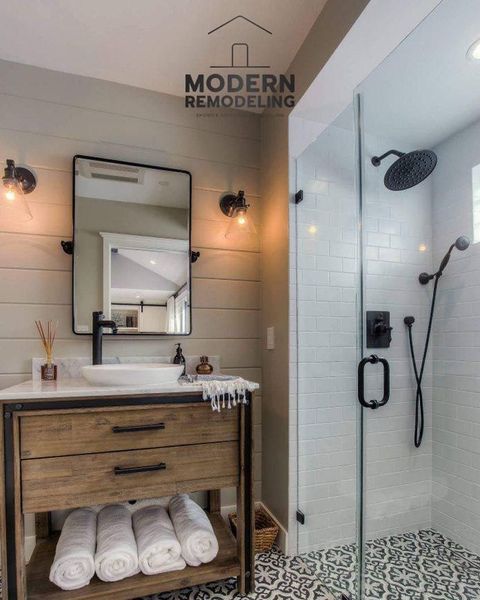 A bathroom with a sink , mirror , and shower.