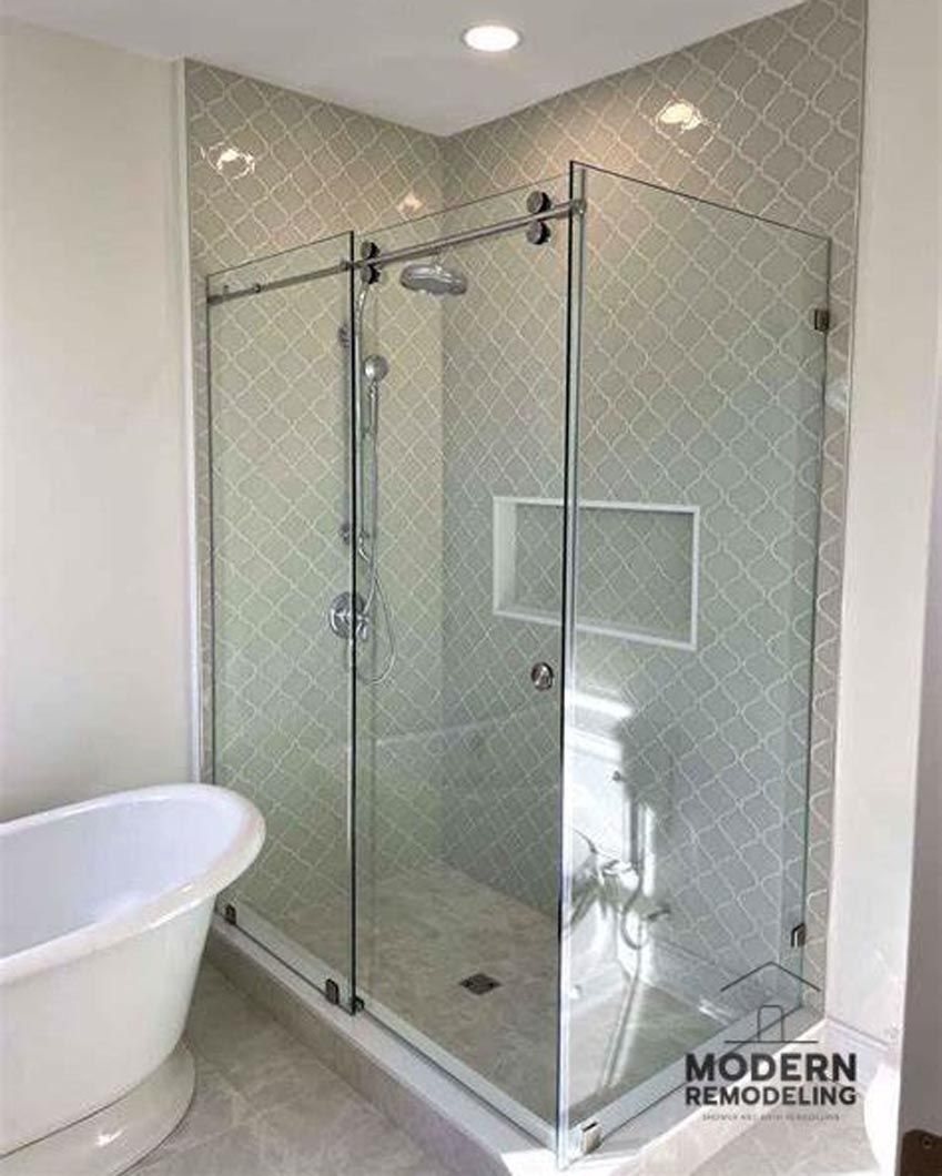 A bathroom with a bathtub and a shower stall with sliding glass doors.