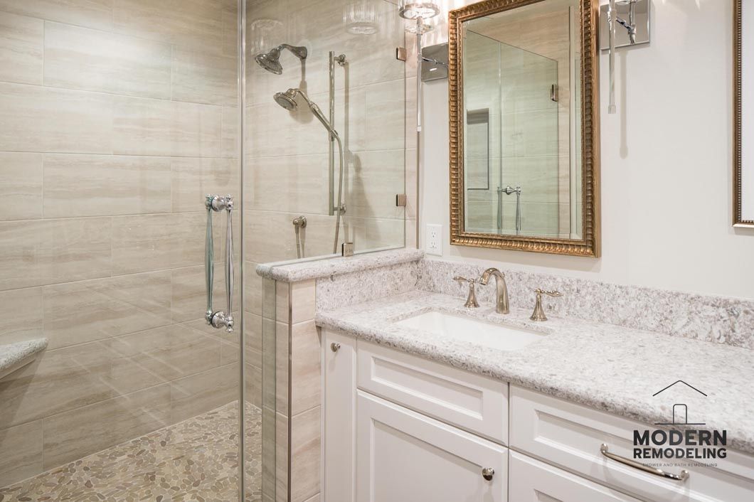 A bathroom with a sink , mirror and walk in shower.