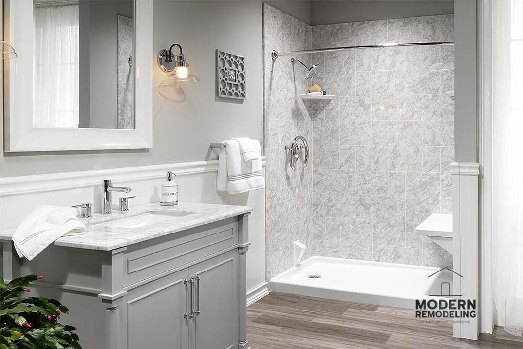 A bathroom with a sink , mirror , and walk in shower.