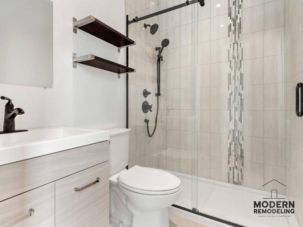 A bathroom with a toilet , sink and shower.