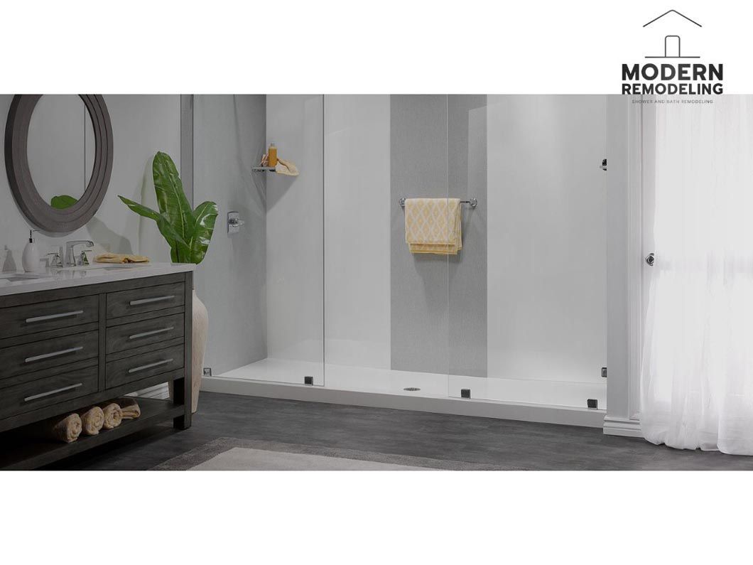 A bathroom with a walk in shower , sink , mirror and vanity.