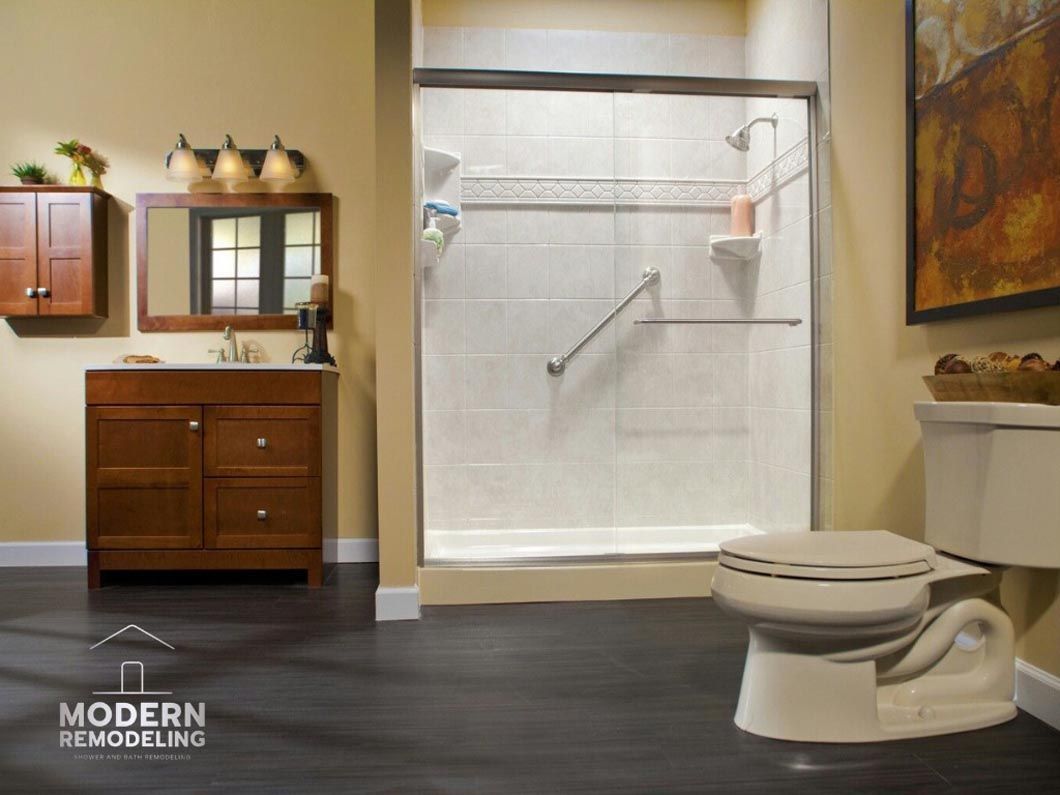 A bathroom with a toilet , sink and shower.