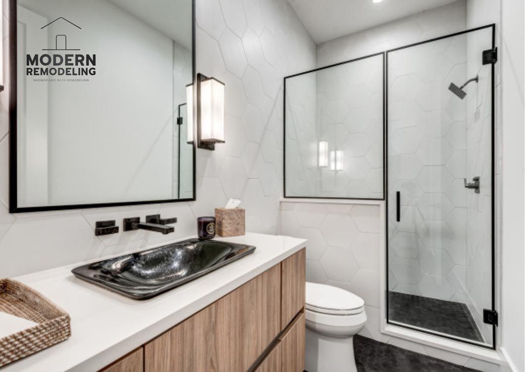 A bathroom with a sink , toilet , shower and mirror.