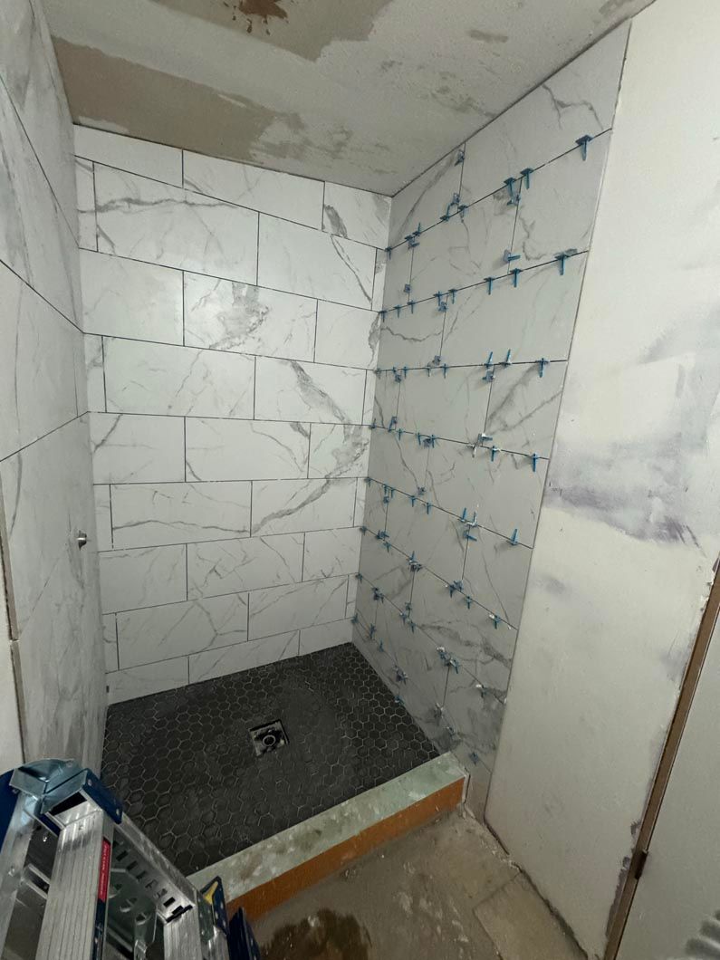 A bathroom with a walk in shower under construction.