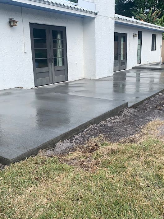 A concrete walkway is being built in front of a white house.