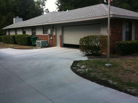 A brick house with a garage and a concrete driveway