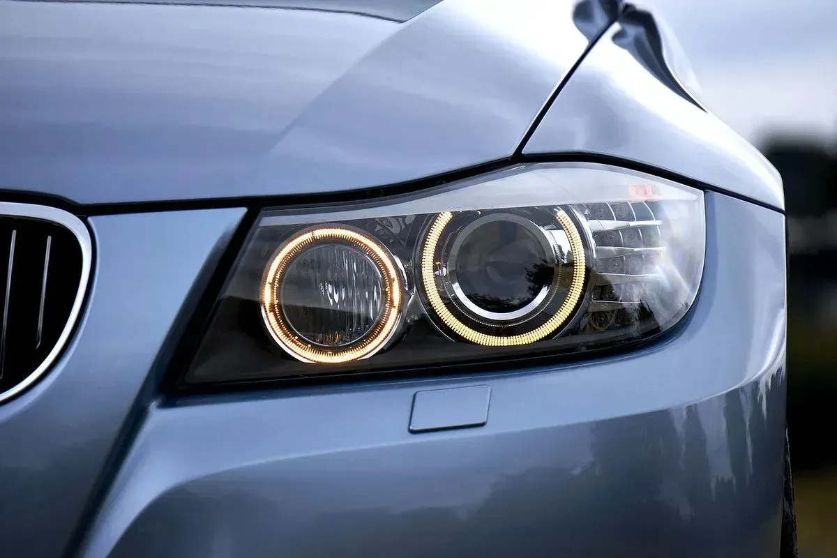 A close up of a car 's headlights on a sunny day.